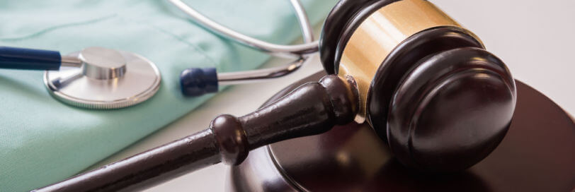 gavel next to medical scrubs and a stethoscope